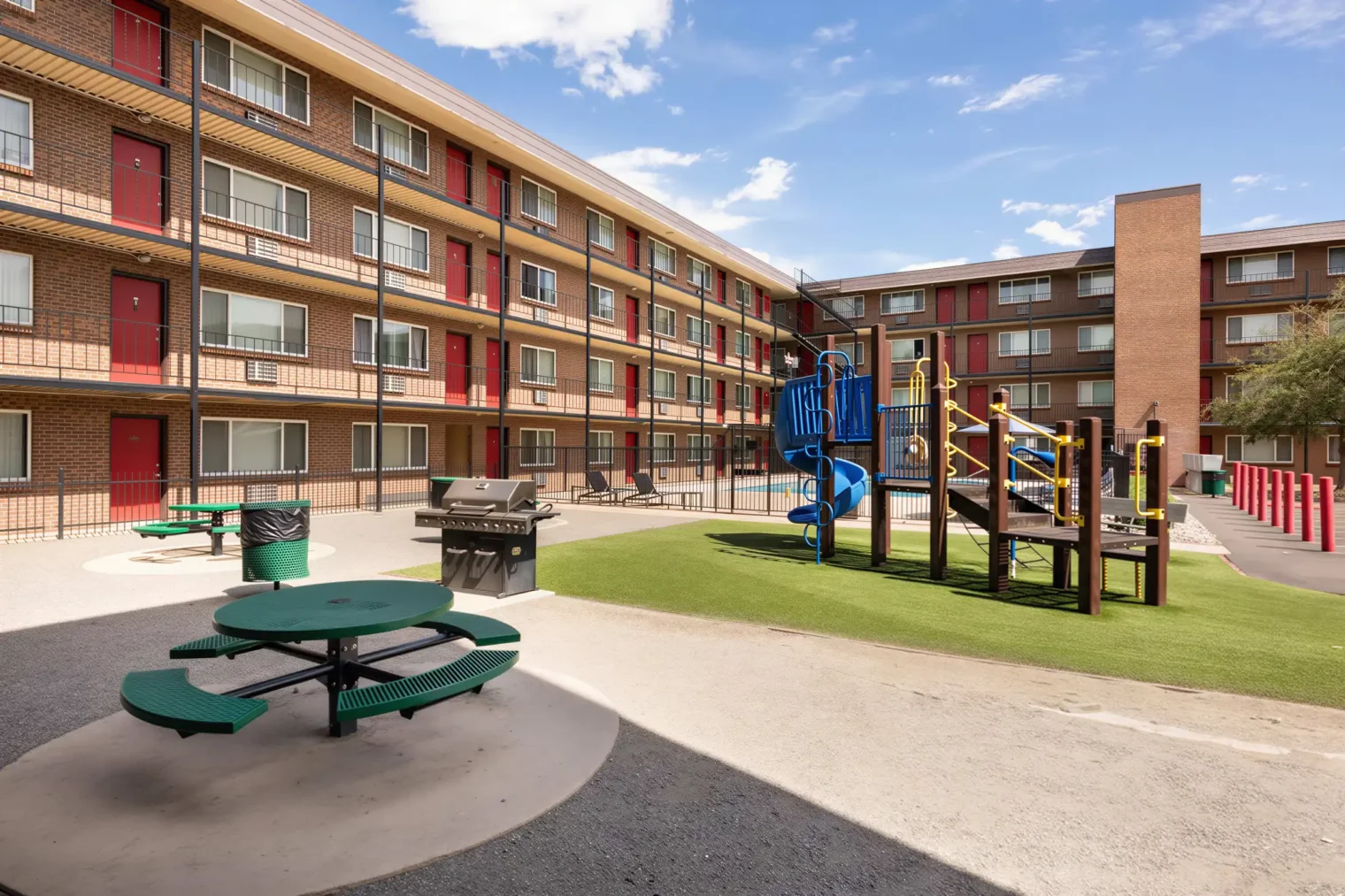 Playground, BBQ grill and picnic area in the open courtyard at Meridian Garden Apartments in Denver, CO